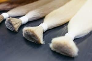 hair extensions of five colors on a dark background. copyspace. top view