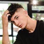 Young Handsome Barber Making Haircut Of teenager Man In Barbershop